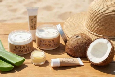 Jars and tubes of Natural Sunscreen with aloe vera and coconuts on a beach table