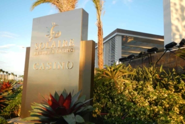 Solaire Resort and Casino entrance sign with tropical landscaping