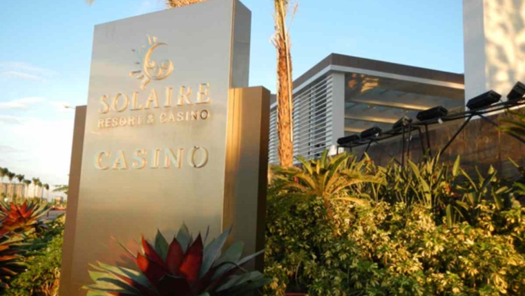 Solaire Resort and Casino entrance sign with tropical landscaping